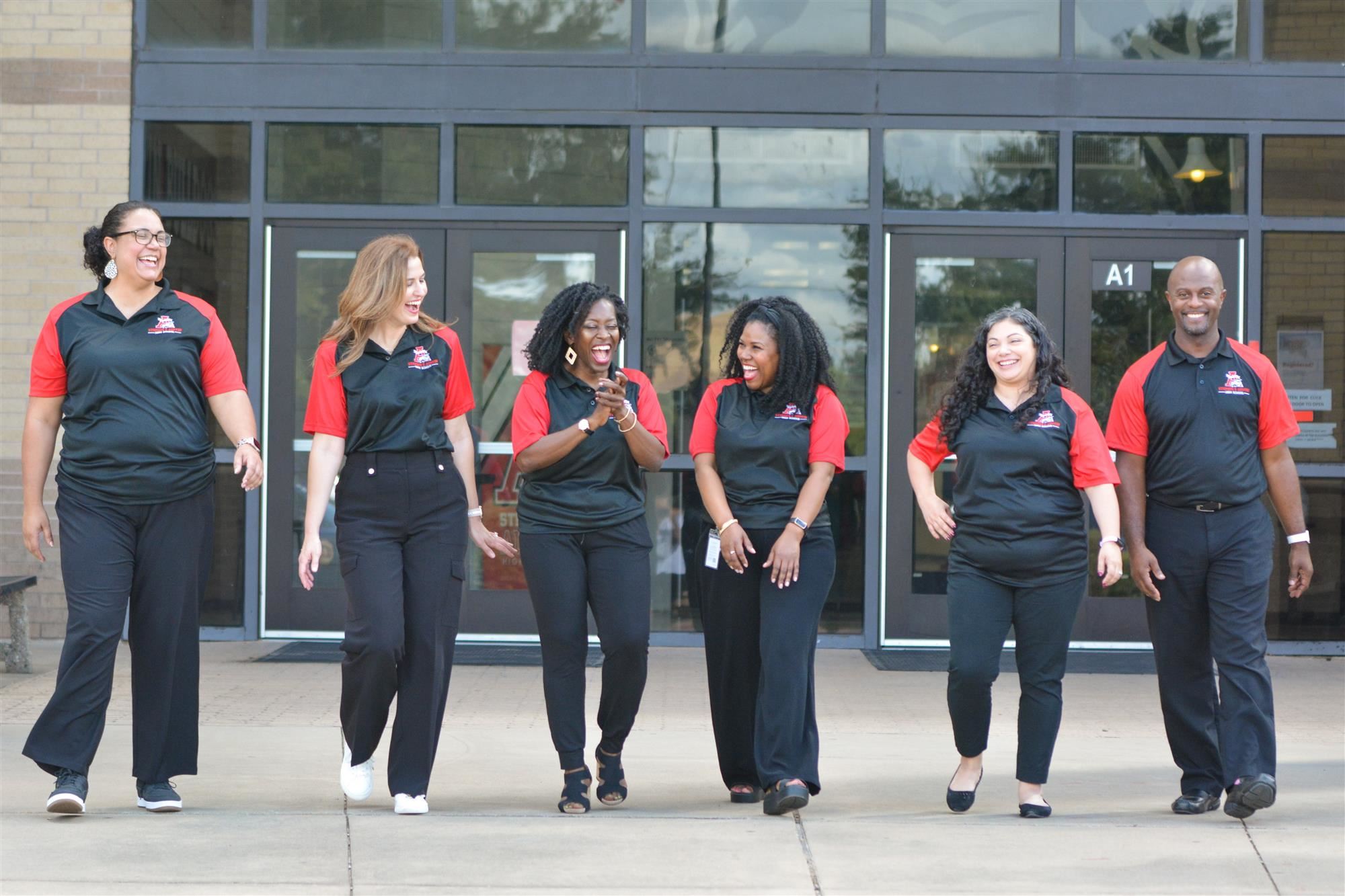 Counseling Team, walking and laughing in front of the school building