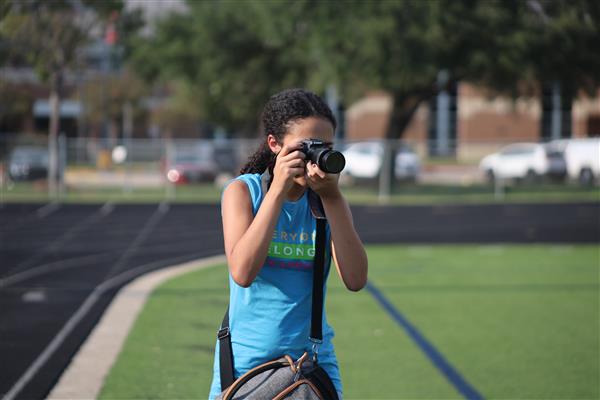 Snap, Pass, Score! Searching for the right moment at the Dulles High School Field, Nedi watches the Vikings through her viewfinder, waiting for the perfect split-second action shot that defines the Wednesday night energy.