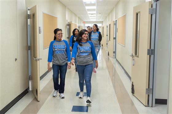 A group of women smiling and posing together in a cheerful setting.